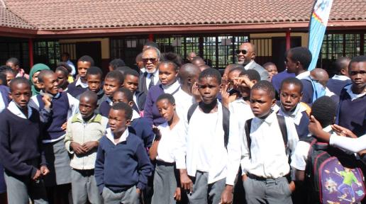RC poses with children at the school
